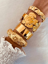 Load image into Gallery viewer, Make a bold statement with this designer 18K gold-plated bangle, featuring a stunning textured flower design. Crafted from high-quality stainless steel for lasting shine, this eye-catching piece exudes elegance and charm. Perfect for stacking or wearing solo, it’s a statement accessory and a beautiful gift for any special occasion!