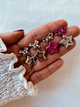 Load image into Gallery viewer, Hand holding small star-shaped jewelry pieces on a light background