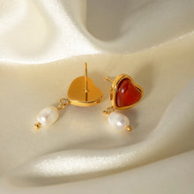 Load image into Gallery viewer, Embrace timeless romance with these stainless steel inlaid onyx heart shape freshwater pearl earrings. Featuring a stunning combination of glossy onyx hearts and delicate freshwater pearls, these earrings exude elegance and charm. Crafted from durable stainless steel, they offer a sophisticated, tarnish-resistant finish, making them perfect for any occasion. A thoughtful and stylish gift for someone special or a beautiful addition to your jewelry collection.