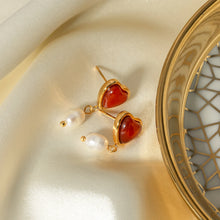 Load image into Gallery viewer, Embrace timeless romance with these stainless steel inlaid onyx heart shape freshwater pearl earrings. Featuring a stunning combination of glossy onyx hearts and delicate freshwater pearls, these earrings exude elegance and charm. Crafted from durable stainless steel, they offer a sophisticated, tarnish-resistant finish, making them perfect for any occasion. A thoughtful and stylish gift for someone special or a beautiful addition to your jewelry collection.