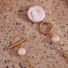 Load image into Gallery viewer, Introducing our elegant stainless steel gold necklace, a timeless piece that combines sophistication with modern design. Crafted from gold-tone stainless steel for durability and a lasting shine, this necklace features a chic toggleclasp adorned with two small natural freshwater pearls for a touch of refined elegance. At the bottom, a striking statement freshwater pearl adds a bold yet graceful focal point, making this necklace the perfect accessory for both special occasions and everyday luxury.