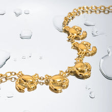Load image into Gallery viewer, This glamorous statement necklace is crafted from stainless steel with a luxurious gold-plated finish. Featuring a bold, thicker chain, it is beautifully adorned with five intricately detailed crab pendants, each capturing the essence of summer's coastal charm. This eye-catching piece adds a touch of elegance to any summer ensemble, instantly elevating your style. Complete with a secure lobster clasp and an adjustable chain, this necklace offers both versatility and comfort.