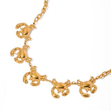 Load image into Gallery viewer, This glamorous statement necklace is crafted from stainless steel with a luxurious gold-plated finish. Featuring a bold, thicker chain, it is beautifully adorned with five intricately detailed crab pendants, each capturing the essence of summer's coastal charm. This eye-catching piece adds a touch of elegance to any summer ensemble, instantly elevating your style. Complete with a secure lobster clasp and an adjustable chain, this necklace offers both versatility and comfort.