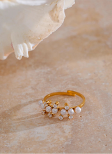Load image into Gallery viewer, Enhance your elegance with this delicate adjustable golden ring, featuring luminous imitation pearls and sparkling zirconia accents. Crafted from durable stainless steel, this stylish ring offers a timeless design perfect for daily wear or special occasions. Its adjustable fit ensures comfort, making it a versatile and thoughtful gift for any woman who loves refined, feminine jewelry.