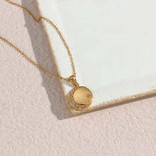 Load image into Gallery viewer, Stainless steel gold plated necklace is made of an elegant and thin chain. There is a round pendant which is adorned with a moon and a star. Both, the moon and the star are made of transparent cubic zirconia. This necklace is a perfect piece for an elegant occasion outfit. It has lobster clasp and adjustable length.