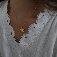 Load image into Gallery viewer, Make a bold statement with this edgy stainless steel star pendant necklace, designed for the modern woman with a punk-inspired aesthetic. Gold-plated for a sleek and stylish finish, this necklace exudes confidence and individuality. The striking star pendant adds a touch of celestial charm, making it the perfect accessory to elevate any look. Whether you're dressing up for a night out or adding a rebellious flair to your everyday style, this necklace is a versatile and eye-catching piece.