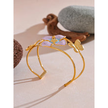 Load image into Gallery viewer, Make a bold statement with our gold-plated stainless steel enamel open bangle, designed for fashionable women who love eye-catching accessories. This stylish bangle features an exaggerated, large design adorned with a delicate butterfly and a vibrant purple flower, adding a whimsical and feminine touch to any outfit. Perfect for making a statement at any occasion, this chic and modern bracelet is a must-have for those who want to stand out with elegance and creativity.