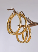 Load image into Gallery viewer, Elevate your style with these minimalistic big hollow hoop earrings, crafted from anti-allergic 316L stainless steel for lasting comfort and durability. Their sleek, round design offers a modern and trendy touch, perfect for adding effortless elegance to any outfit. Lightweight and versatile, these simple yet bold earrings are a must-have accessory for everyday wear or special occasions.