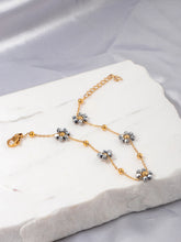 Load image into Gallery viewer, Elevate your look with this delicate stainless steel bracelet, beautifully gold-plated for a touch of luxury and adorned with intricate small grey beaded flowers. The fine craftsmanship of the floral accents adds a subtle charm, making this bracelet an elegant addition to any outfit. Its refined design is perfect for everyday wear or special occasions, offering a graceful balance between simplicity and sophistication.