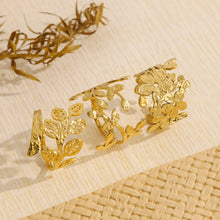 Load image into Gallery viewer, This striking stainless steel ring features a captivating design with a delicate leaf motif paired with an eye-catching irregular line, offering a perfect blend of nature-inspired elegance and modern artistry. Coated in luxurious 18K gold plating, the ring’s unique texture adds depth and character, making it a standout piece for any occasion. Waterproof and crafted for lasting durability, it’s as practical as it is stylish—ideal for the trendsetter who loves to wear distinctive, high-fashion pieces that ref