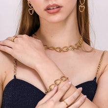 Load image into Gallery viewer, This stunning bracelet is crafted from stainless steel and plated with real gold, giving it a radiant golden hue. Featuring a series of beautifully irregular heart-shaped links, it offers a unique and eye-catching design. The elegant toggle clasp adds an extra touch of sophistication, making this bracelet as practical as it is stylish. A true statement piece, this bracelet effortlessly enhances any outfit, adding a sense of elegance and distinctive charm to your look.