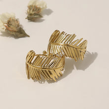 Load image into Gallery viewer, Embrace nature-inspired elegance with this stunning irregular leaf stainless steel ring, designed to make a bold yet refined statement. The ring's unique, asymmetrical leaf design creates an eye-catching, chic look that's perfect for the modern woman who loves to stand out. Crafted from durable, waterproof stainless steel, this trendy piece effortlessly blends creativity with everyday wear. Whether you're styling it for casual outings or adding flair to a more polished ensemble, this ring is the perfect acc