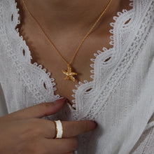 Load image into Gallery viewer, Make a bold statement with this edgy stainless steel star pendant necklace, designed for the modern woman with a punk-inspired aesthetic. Gold-plated for a sleek and stylish finish, this necklace exudes confidence and individuality. The striking star pendant adds a touch of celestial charm, making it the perfect accessory to elevate any look. Whether you're dressing up for a night out or adding a rebellious flair to your everyday style, this necklace is a versatile and eye-catching piece.