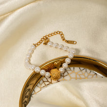 Load image into Gallery viewer, This elegant, vintage-inspired bracelet is crafted from lustrous pearls and features a striking gold-tone hammered stainless steel ball, adding a touch of timeless sophistication. The intricate detailing of the embossed ball beautifully complements the classic pearl design, making this bracelet the perfect accessory for any glamorous or elegant outfit. Finished with a secure lobster clasp and an adjustable chain, it ensures a comfortable and customizable fit.
