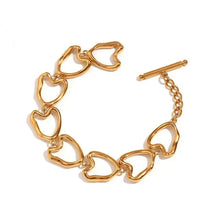 Load image into Gallery viewer, This stunning bracelet is crafted from stainless steel and plated with real gold, giving it a radiant golden hue. Featuring a series of beautifully irregular heart-shaped links, it offers a unique and eye-catching design. The elegant toggle clasp adds an extra touch of sophistication, making this bracelet as practical as it is stylish. A true statement piece, this bracelet effortlessly enhances any outfit, adding a sense of elegance and distinctive charm to your look.