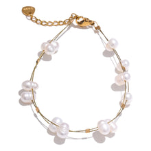 Load image into Gallery viewer, This beautiful handmade bracelet, crafted from stainless steel, features a delicate double-chain design that radiates elegance and sophistication. The fine chains are adorned with shimmering golden cubes and natural freshwater pearls, offering a perfect blend of modern charm and timeless grace. Ideal for glamorous occasions, this bracelet adds a touch of refined class to any outfit. Designed with both style and comfort in mind, it includes a secure lobster clasp and an adjustable length to ensure a perfect