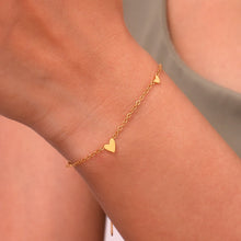 Load image into Gallery viewer, Embrace timeless elegance with this minimalist three heart O-Chain bracelet, crafted from premium stainless steel for a sleek and durable finish. Featuring a delicate chain adorned with three romantic heart charms, this bracelet adds a touch of luxury and femininity to any look. Perfect for everyday wear or special occasions, it’s a versatile and stylish accessory for any modern woman.