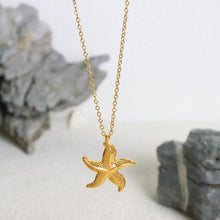 Load image into Gallery viewer, Make a bold statement with this edgy stainless steel star pendant necklace, designed for the modern woman with a punk-inspired aesthetic. Gold-plated for a sleek and stylish finish, this necklace exudes confidence and individuality. The striking star pendant adds a touch of celestial charm, making it the perfect accessory to elevate any look. Whether you're dressing up for a night out or adding a rebellious flair to your everyday style, this necklace is a versatile and eye-catching piece.
