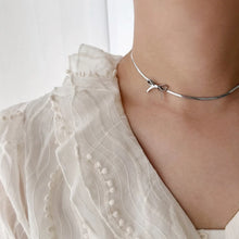 Load image into Gallery viewer, This minimalist choker necklace features a delicate knot bow design, crafted from a sleek, 18K gold-plated tiny snake chain that sits elegantly on the neck. Made from high-quality stainless steel, it combines simplicity with sophistication, making it the perfect accessory for weddings or special occasions.