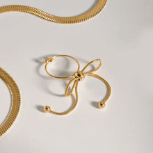 Load image into Gallery viewer, This elegant open slim ring features a charming bow design with delicate tassel accents, crafted from durable stainless steel and plated in radiant 18K gold. Waterproof and stylish, it’s perfect for daily wear or special occasions, offering a blend of sophistication and modern flair. A versatile accessory for women and girls, this new arrival adds a graceful touch to any jewelry collection.