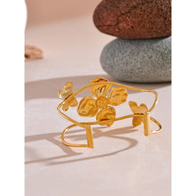 Load image into Gallery viewer, Make a bold statement with our gold-plated stainless steel enamel open bangle, designed for fashionable women who love eye-catching accessories. This stylish bangle features an exaggerated, large design adorned with a delicate butterfly and a vibrant purple flower, adding a whimsical and feminine touch to any outfit. Perfect for making a statement at any occasion, this chic and modern bracelet is a must-have for those who want to stand out with elegance and creativity.