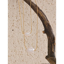 Load image into Gallery viewer, This glamorous stainless steel necklace features an elegant double chain design, each strand adorned with a single, lustrous natural freshwater pearl. The larger pearls add a touch of sophistication and elevate the necklace's overall style, making it a striking accessory. Perfect for complementing an evening outfit or adding a touch of elegance to your daily look, this versatile piece is both stylish and refined. The necklace is finished with a secure lobster clasp and an adjustable chain.