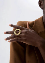 Load image into Gallery viewer, This bold stainless steel ring features a large, open round design crafted from interlocking hammered circles, creating a unique and eye-catching look. Its hollow, hyperbolic shape gives it a personalized, vintage-inspired appeal, perfect for adding a stylish, edgy touch to any outfit. With its trendy, textured metal and artistic detail, this ring is a standout piece for those who love statement jewelry that exudes individuality and modern charm.