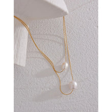 Load image into Gallery viewer, This glamorous stainless steel necklace features an elegant double chain design, each strand adorned with a single, lustrous natural freshwater pearl. The larger pearls add a touch of sophistication and elevate the necklace's overall style, making it a striking accessory. Perfect for complementing an evening outfit or adding a touch of elegance to your daily look, this versatile piece is both stylish and refined. The necklace is finished with a secure lobster clasp and an adjustable chain.