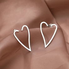 Load image into Gallery viewer, Make a bold statement with these exaggerated heart contour stainless steel stud earrings. Featuring a striking heart-shaped design, these earrings combine modern fashion with timeless elegance. Lightweight and durable, they’re perfect for adding a touch of flair to any outfit. A must-have accessory for women who love unique and stylish jewelry, these earrings are ideal for both everyday wear and special occasions.