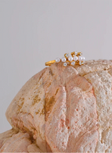 Load image into Gallery viewer, Enhance your elegance with this delicate adjustable golden ring, featuring luminous imitation pearls and sparkling zirconia accents. Crafted from durable stainless steel, this stylish ring offers a timeless design perfect for daily wear or special occasions. Its adjustable fit ensures comfort, making it a versatile and thoughtful gift for any woman who loves refined, feminine jewelry.