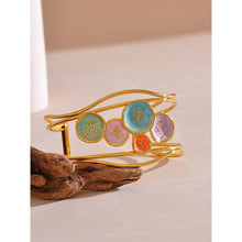 Load image into Gallery viewer, Make a bold statement with our gold-plated stainless steel colorful enamel open angle, designed for fashionable women who love eye-catching accessories. This stylish bangle features an exaggerated, large design adorned with five vibrant enamel circles in red, purple, turquoise, green, and pink, adding a playful splash of color to any outfit. Perfect for making a statement at any occasion, this chic and modern bracelet is a must-have for those who want to stand out with elegance and creativity.
