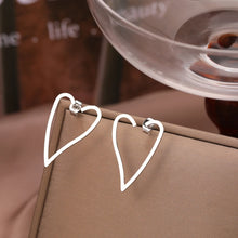 Load image into Gallery viewer, Make a bold statement with these exaggerated heart contour stainless steel stud earrings. Featuring a striking heart-shaped design, these earrings combine modern fashion with timeless elegance. Lightweight and durable, they’re perfect for adding a touch of flair to any outfit. A must-have accessory for women who love unique and stylish jewelry, these earrings are ideal for both everyday wear and special occasions.