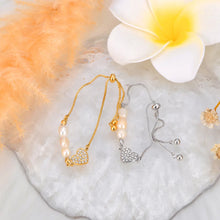 Load image into Gallery viewer, Add a touch of elegance to your look with this stainless steel heart charm bracelet. Adorned with natural pearls and a sparkling zircon heart pendant, and finished with 18K gold plating, this bracelet exudes timeless sophistication. Perfect for women who love graceful and versatile accessories, it’s a stunning piece for both everyday wear and special occasions. A thoughtful gift or a chic addition to any jewelry collection.