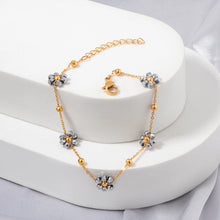 Load image into Gallery viewer, Elevate your look with this delicate stainless steel bracelet, beautifully gold-plated for a touch of luxury and adorned with intricate small grey beaded flowers. The fine craftsmanship of the floral accents adds a subtle charm, making this bracelet an elegant addition to any outfit. Its refined design is perfect for everyday wear or special occasions, offering a graceful balance between simplicity and sophistication.