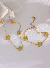 Load image into Gallery viewer, This delicate and classy bracelet is made out of stainless steel with 18K gold plating. It consists of a thin chain with three flower charms and it comes in gold colour. It has a size adjustable lobster clasp. It can be worn as a perfect summer accessory.