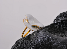 Load image into Gallery viewer, This exquisite adjustable ring showcases a delicate white enamel flower, set on durable, waterproof stainless steel for a chic yet enduring design. With its elegant floral detailing, this ring adds a refined, feminine touch to any outfit, embodying a timeless yet fashion-forward aesthetic. Perfect for daily wear or special occasions, it’s a versatile piece that complements any style.