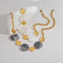 Load image into Gallery viewer, Illuminate your style with this elegant necklace, featuring a radiant sun pendant paired with a shell disc in your choice of white or black. Crafted from 18K gold-plated stainless steel, this waterproof piece offers both durability and sophistication. Perfect for layering or wearing solo, it adds a timeless charm to any outfit, making it a thoughtful gift for any jewelry lover.