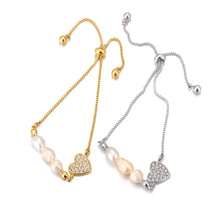 Load image into Gallery viewer, Add a touch of elegance to your look with this stainless steel heart charm bracelet. Adorned with natural pearls and a sparkling zircon heart pendant, and finished with 18K gold plating, this bracelet exudes timeless sophistication. Perfect for women who love graceful and versatile accessories, it’s a stunning piece for both everyday wear and special occasions. A thoughtful gift or a chic addition to any jewelry collection.