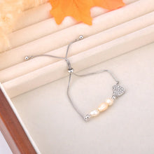 Load image into Gallery viewer, Add a touch of elegance to your look with this stainless steel heart charm bracelet. Adorned with natural pearls and a sparkling zircon heart pendant, and finished with 18K gold plating, this bracelet exudes timeless sophistication. Perfect for women who love graceful and versatile accessories, it’s a stunning piece for both everyday wear and special occasions. A thoughtful gift or a chic addition to any jewelry collection.
