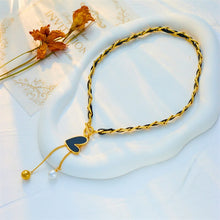 Load image into Gallery viewer, This statement rock glam necklace is made of stainless steel and leather strap. It has nice toggle clasp with a black heart hanging on it. There are two chains hanging from the heart that are endings with a gold and a white pearl. It is a perfect piece for an elegant occasion outfit as well as a nice gift for your special ones.