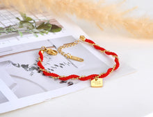 Load image into Gallery viewer, Embrace timeless elegance with this combined ethnic red rope and chain bracelet, crafted from durable titanium stainless steel and plated with 18K gold for a luxurious finish. Featuring a trendy design with a good luck charm, this bracelet combines style and symbolism, making it perfect for everyday wear or as a meaningful gift for women who value both fashion and tradition.