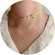 Load image into Gallery viewer, This minimalist choker necklace features a delicate knot bow design, crafted from a sleek, 18K gold-plated tiny snake chain that sits elegantly on the neck. Made from high-quality stainless steel, it combines simplicity with sophistication, making it the perfect accessory for weddings or special occasions.