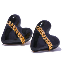 Load image into Gallery viewer, These trendy heart stud earrings feature a chic black or white enamel finish, adorned with a delicate golden chain that adds a unique touch of elegance. Crafted from high-quality 18K plated stainless steel, they exude lasting charm and sophistication. Their romantic design combines classic style with a modern twist, making them a perfect accessory for women who love eye-catching yet versatile jewelry.