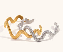 Load image into Gallery viewer, This striking open bangle bracelet features a unique hammered pattern and a sleek snake design, crafted from waterproof stainless steel for durability and style. Its bold, textured look adds an edgy yet elegant touch to any outfit, making it a perfect statement piece for fashion-forward women.