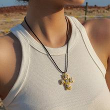 Load image into Gallery viewer, This glam rock necklace is made of stainless steel pendant which is hanging on a black wax rope. The beautiful cross pendant comes in two colours: gold and silver. It has irregular surface which is additionally adorned with 5 big cubic zirconia. It is a perfect piece for any daily occasion as well a great gift for your beloved friend. The necklace has lobster clasp and adjustable chain.