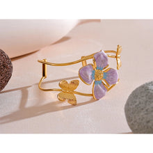 Load image into Gallery viewer, Make a bold statement with our gold-plated stainless steel enamel open bangle, designed for fashionable women who love eye-catching accessories. This stylish bangle features an exaggerated, large design adorned with a delicate butterfly and a vibrant purple flower, adding a whimsical and feminine touch to any outfit. Perfect for making a statement at any occasion, this chic and modern bracelet is a must-have for those who want to stand out with elegance and creativity.
