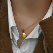 Load image into Gallery viewer, Stainless steel gold plated necklace is made of an elegant and thin chain. There is a round pendant which is adorned with a moon and a star. Both, the moon and the star are made of transparent cubic zirconia. This necklace is a perfect piece for an elegant occasion outfit. It has lobster clasp and adjustable length.