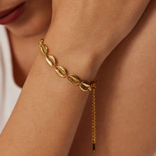 Load image into Gallery viewer, This exquisite stainless steel hollow shell bracelet in radiant 18K gold color is a beautiful blend of elegance and nature-inspired design. Featuring a delicate line of intricately crafted hollow shells, this bracelet is PVD plated for extra durability and a luxurious finish. Its waterproof quality makes it perfect for everyday wear, adding a touch of timeless charm to any outfit.