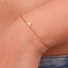 Load image into Gallery viewer, Embrace timeless elegance with this minimalist three heart O-Chain bracelet, crafted from premium stainless steel for a sleek and durable finish. Featuring a delicate chain adorned with three romantic heart charms, this bracelet adds a touch of luxury and femininity to any look. Perfect for everyday wear or special occasions, it’s a versatile and stylish accessory for any modern woman.