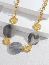 Load image into Gallery viewer, Illuminate your style with this elegant necklace, featuring a radiant sun pendant paired with a shell disc in your choice of white or black. Crafted from 18K gold-plated stainless steel, this waterproof piece offers both durability and sophistication. Perfect for layering or wearing solo, it adds a timeless charm to any outfit, making it a thoughtful gift for any jewelry lover.